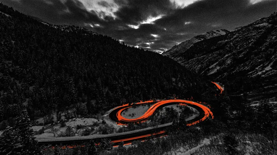 Serpentinenstraße bei Nacht mit oranger Lichtspur